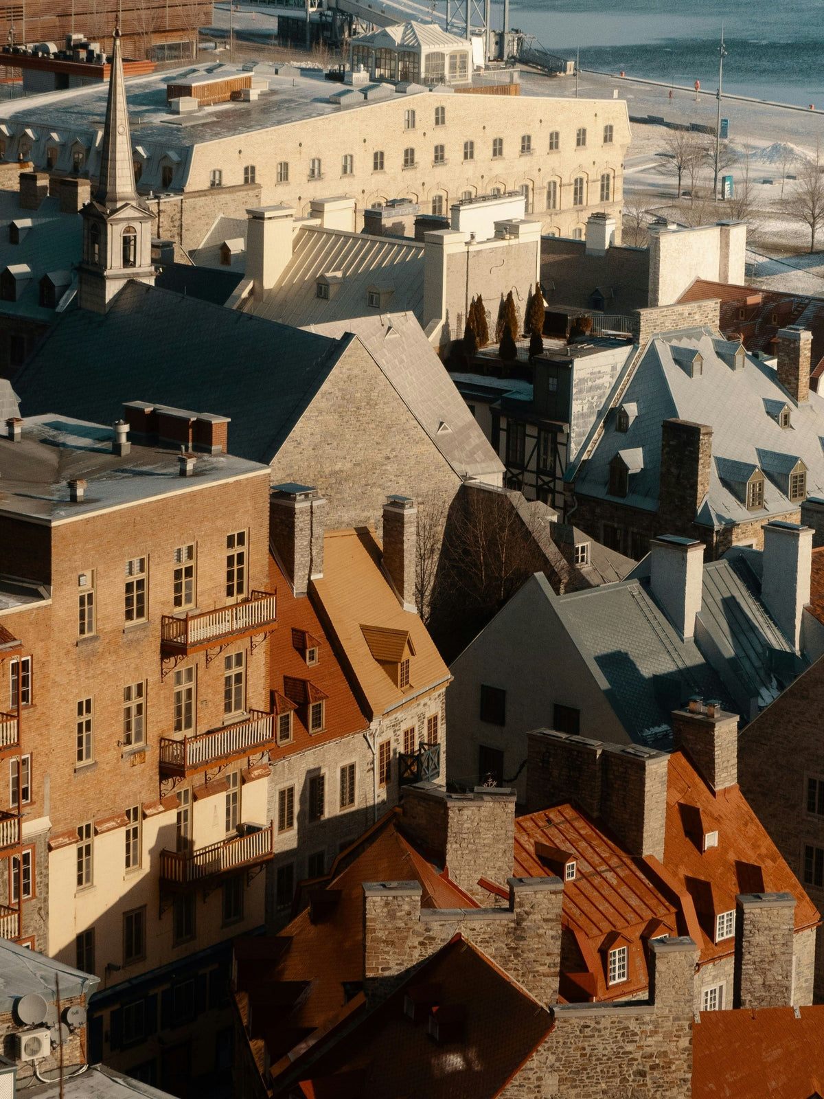 Aerial view of historic rooftops dusted with snow in Old Quebec City