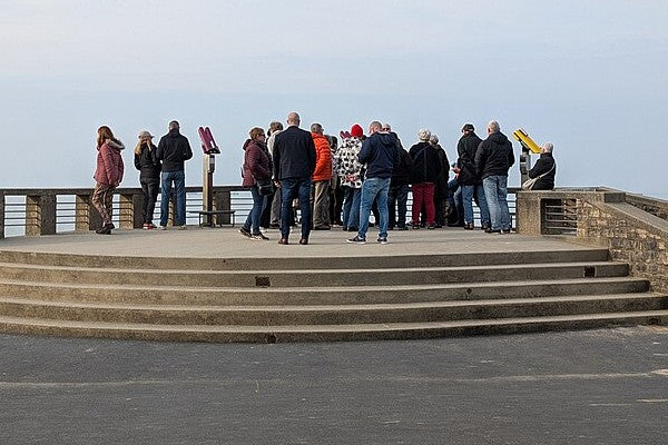 A mixed group of travelers gathered together at a scenic overlook