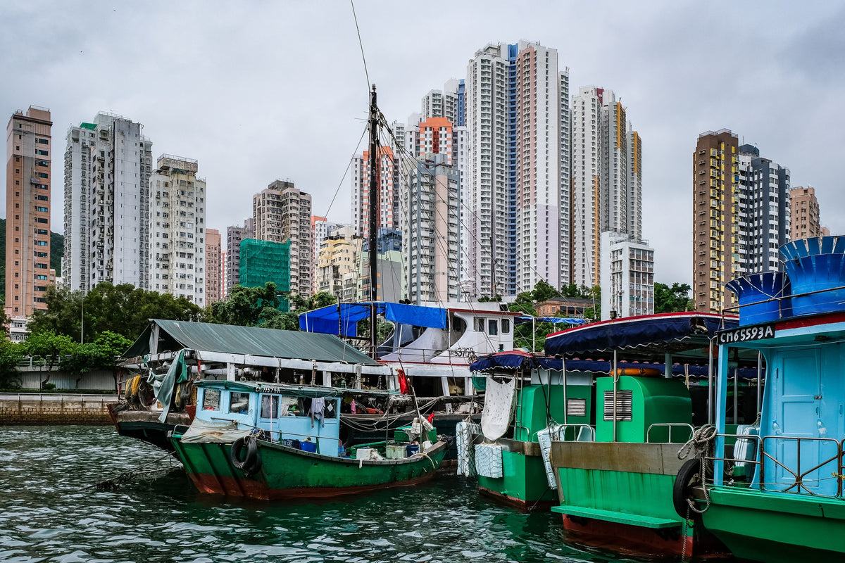 Colorful fishing boats in Hong Kong harbor against the skyline