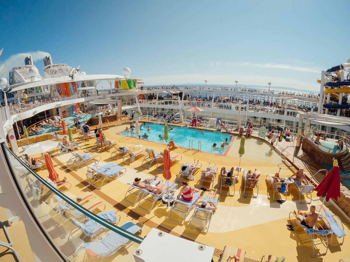 Families relaxing by the pool on a cruise ship sun deck
