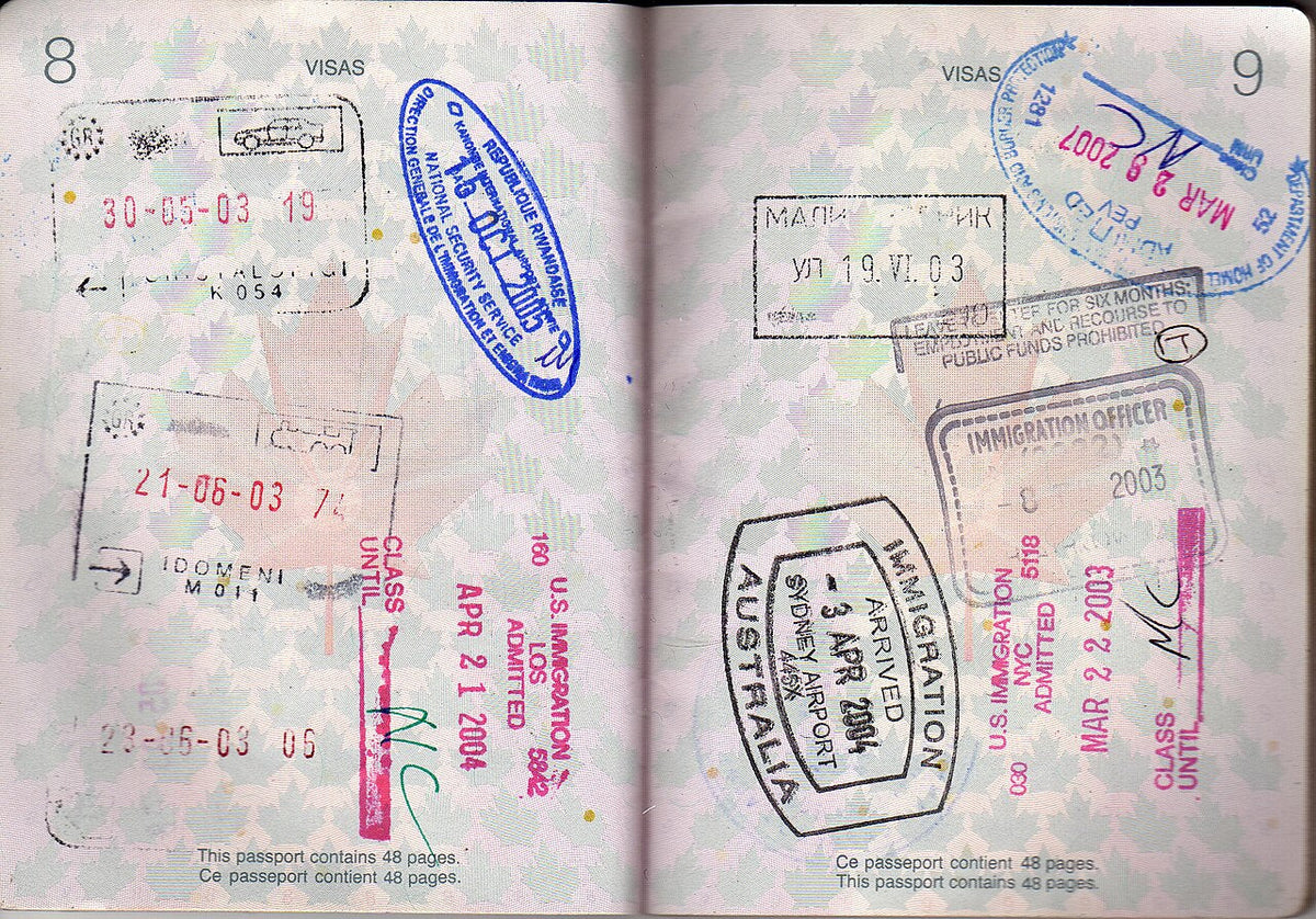 Open passport pages covered in visa and entry stamps