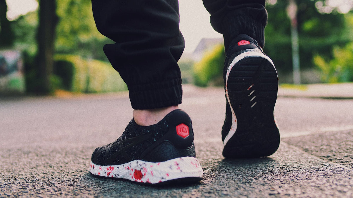 Person walking in black sneakers on a city street