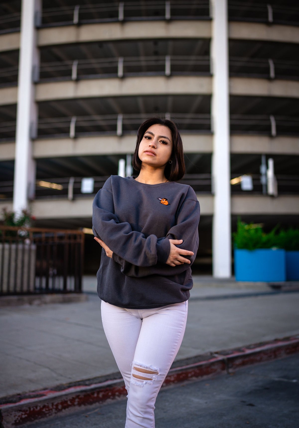 Woman wearing a gray sweatshirt and jeans outdoors