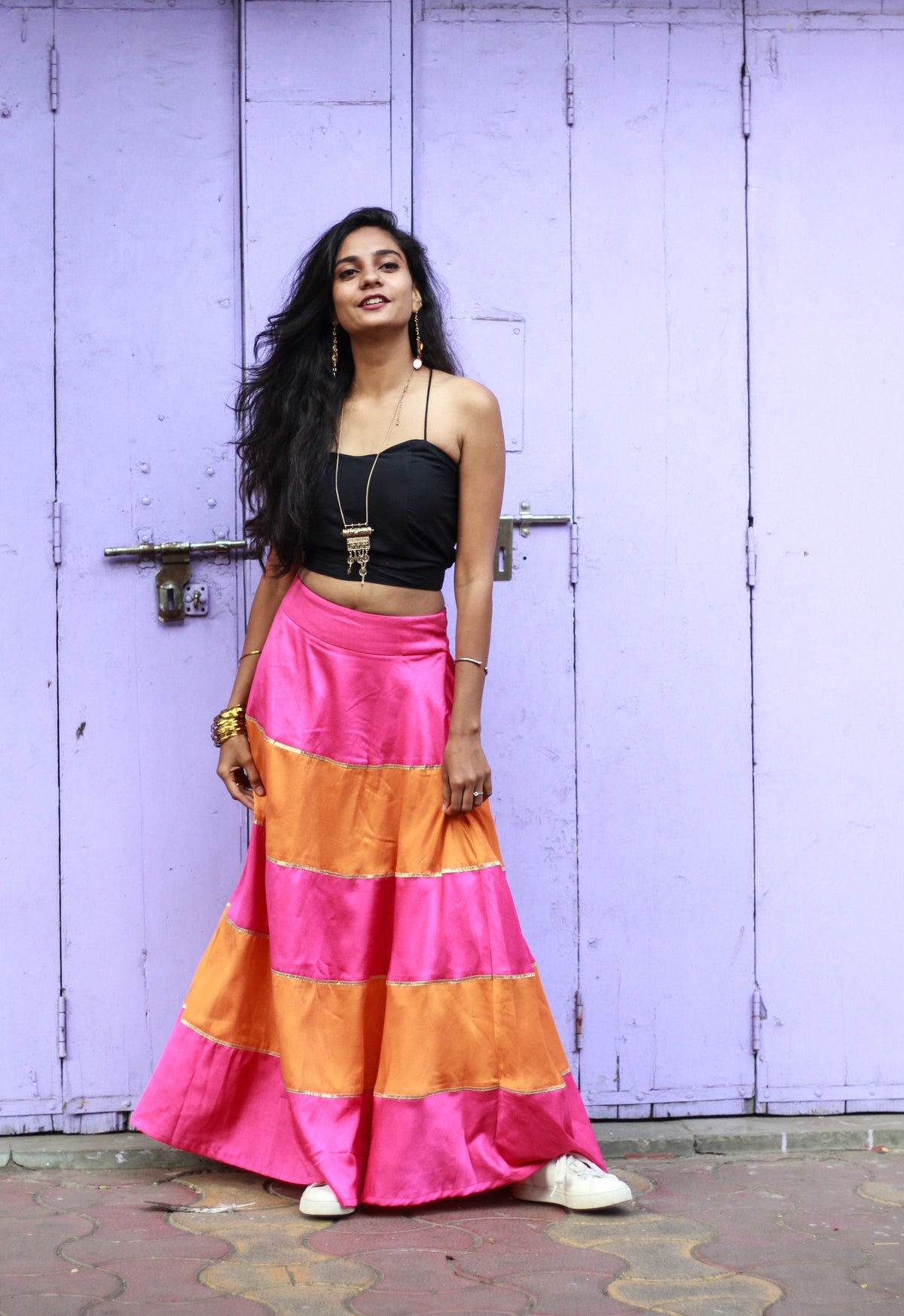 Woman wearing a black crop top and colorful maxi skirt
