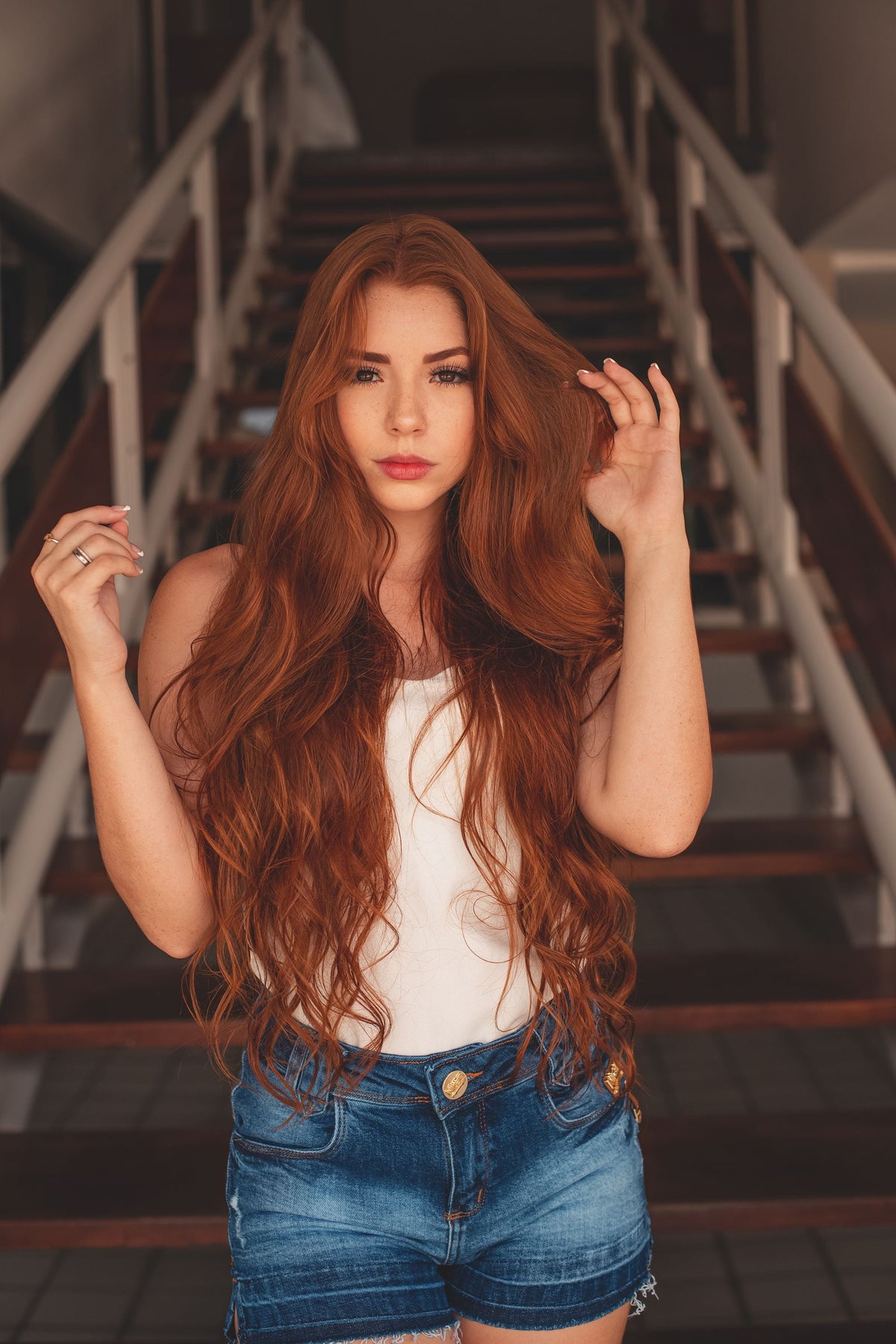 Woman wearing a white tank top and denim shorts