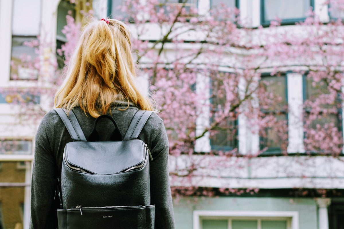 Woman wearing a black leather backpack on a city street