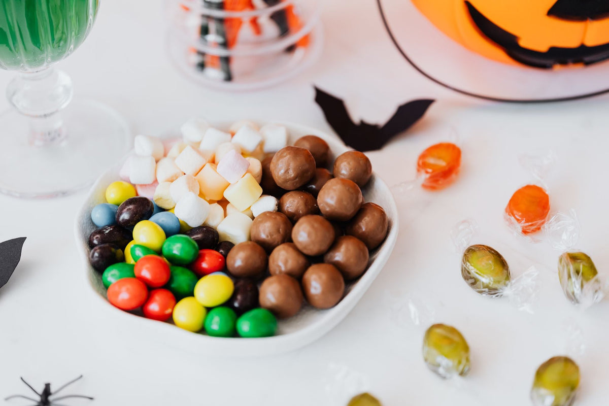 Bowl of Halloween candy on a table with holiday decorations