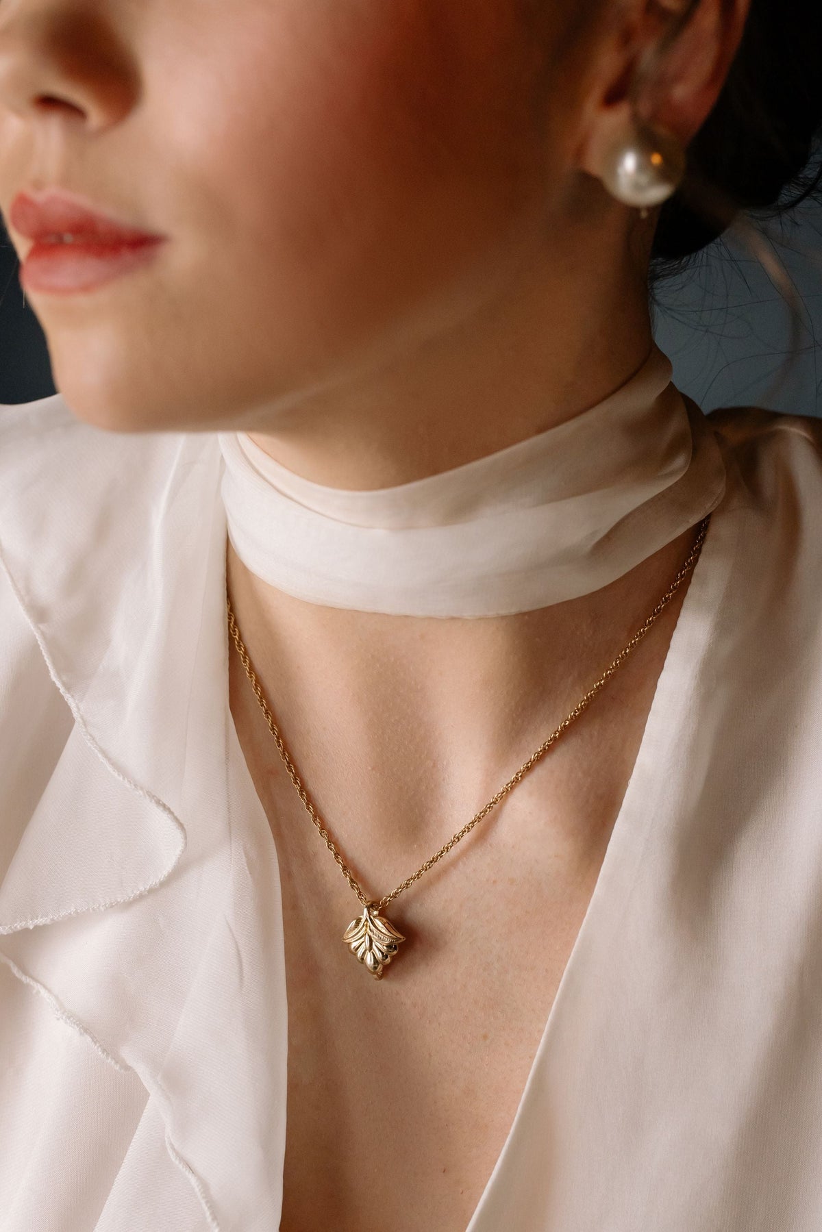Close up of woman wearing a gold pendant necklace