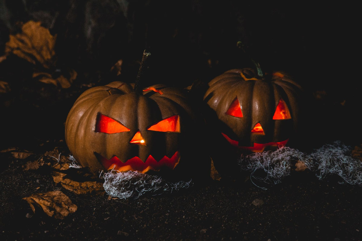 Two carved jack-o-lanterns glowing at night
