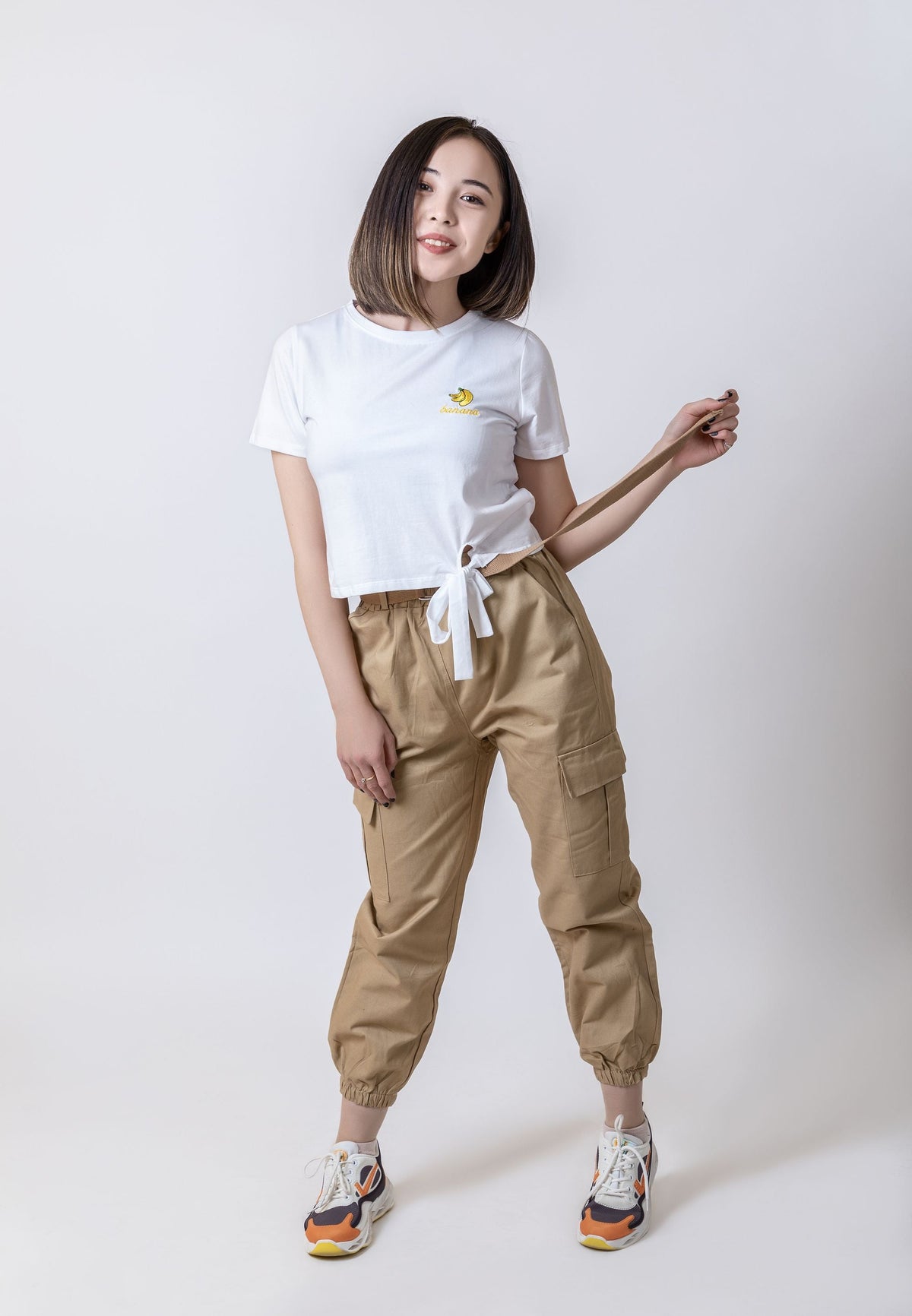 Woman wearing a white cropped tee and cargo pants