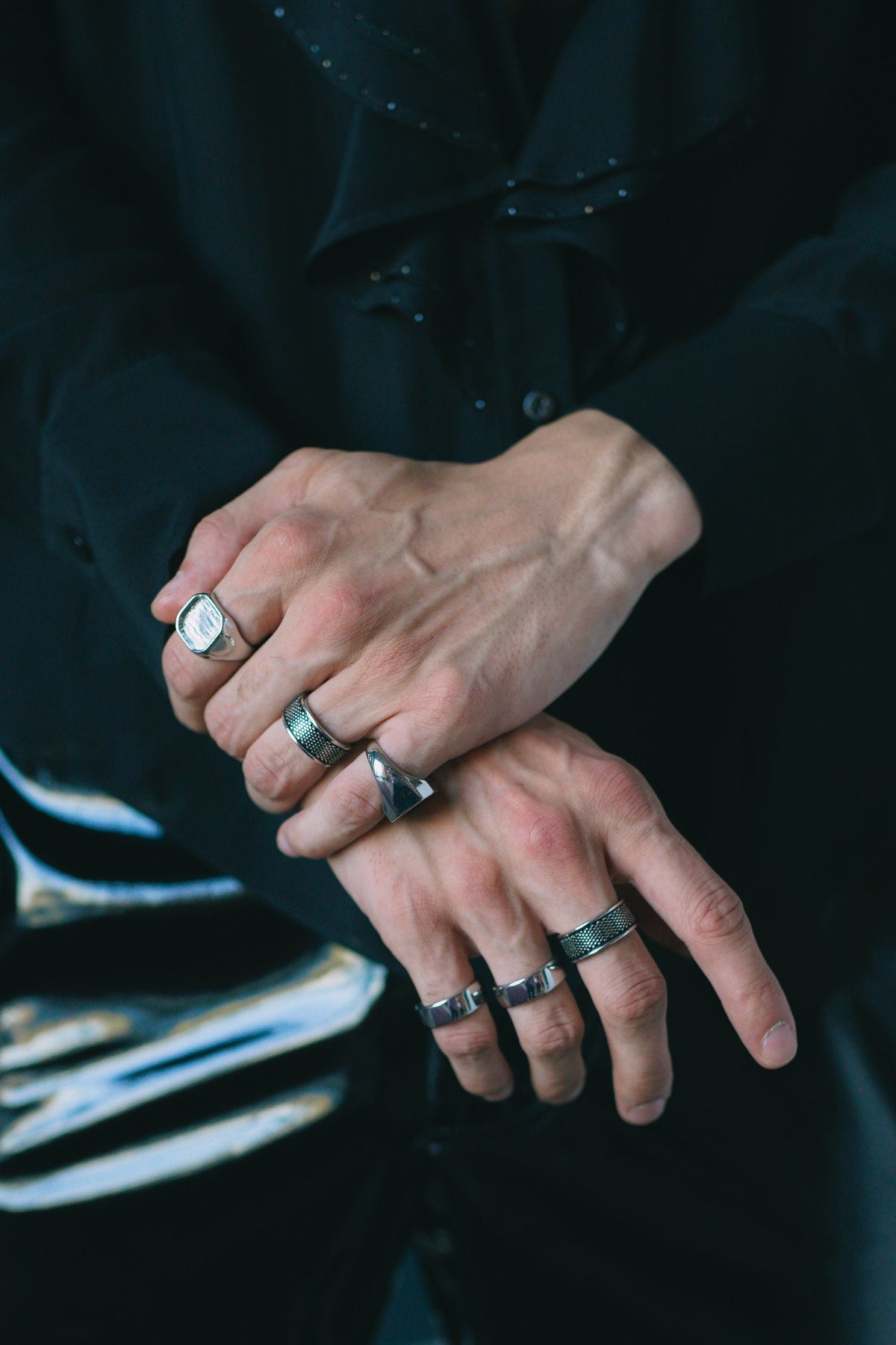 Man's hand with chunky silver signet rings