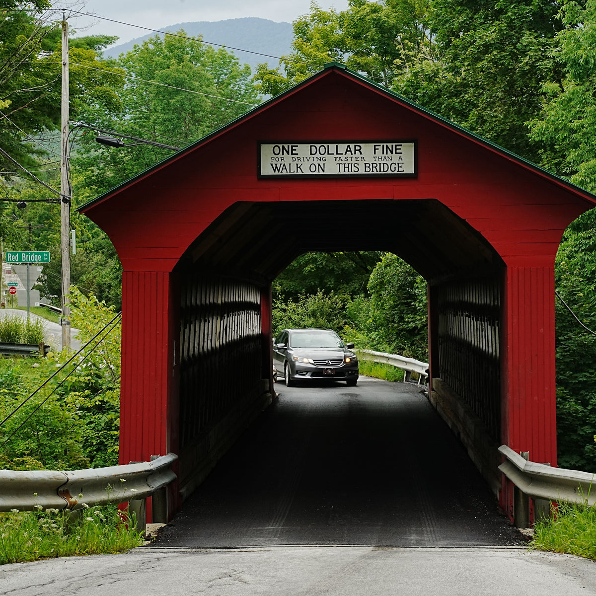 Historic red covered bridge in a New England autumn landscape