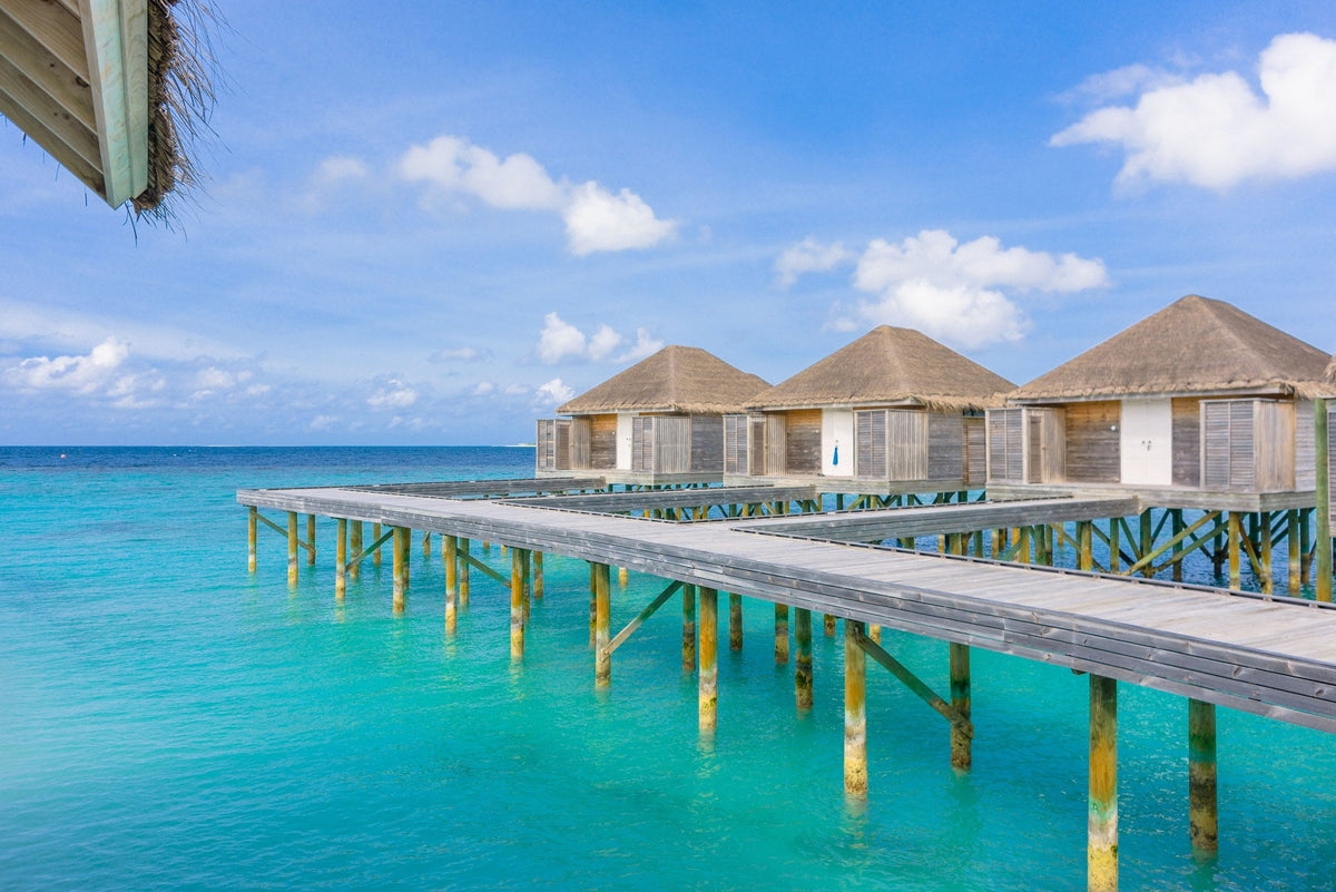 Overwater bungalows above turquoise water in the Maldives