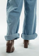 Stylish women's metallic accent ankle boots paired with rolled-up blue denim jeans