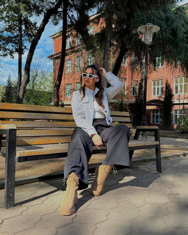Stylish woman wearing tan suede lace up boots for women while sitting on a park bench