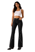 Woman wearing black flared jeans with white embellishments on a beige background