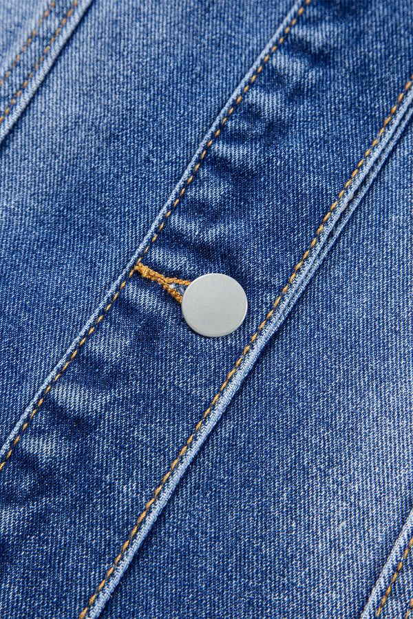 Close-up of a blue denim fabric with a button