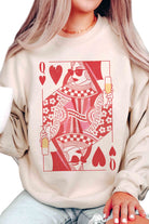 Person wearing a cream sweatshirt with a red and white graphic design of a queen of hearts playing card.