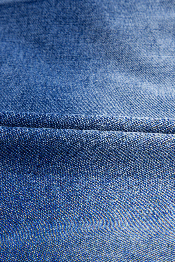 Close-up of blue denim fabric with a subtle pattern