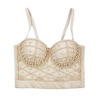 Beige bralette with pearl embellishments on a light blue background