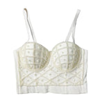 White beaded bralette on a textured gray surface