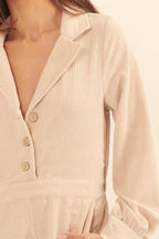 Beige corduroy romper for vacation featuring a collared neck and button details