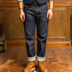 Person wearing dark blue jeans and brown shoes in a wooden interior setting