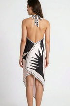 Woman wearing a black, white, and beige dress with a leaf pattern on a white background