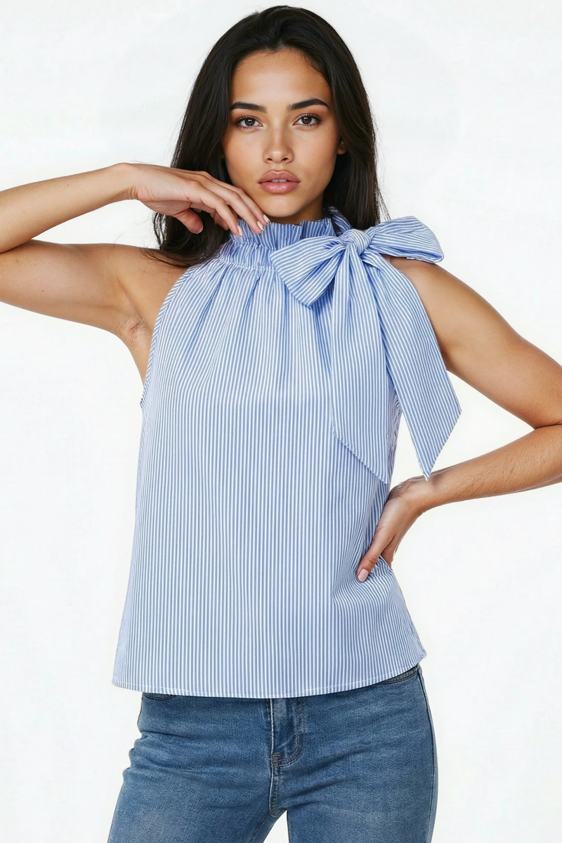 Woman wearing a blue and white striped halter top with a bow detail on a white background