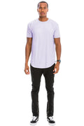Man wearing a light purple t-shirt and black pants on a white background