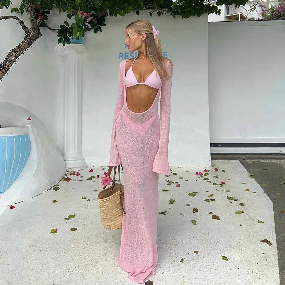 Woman in a pink outfit standing outdoors with a white wall and pool in the background