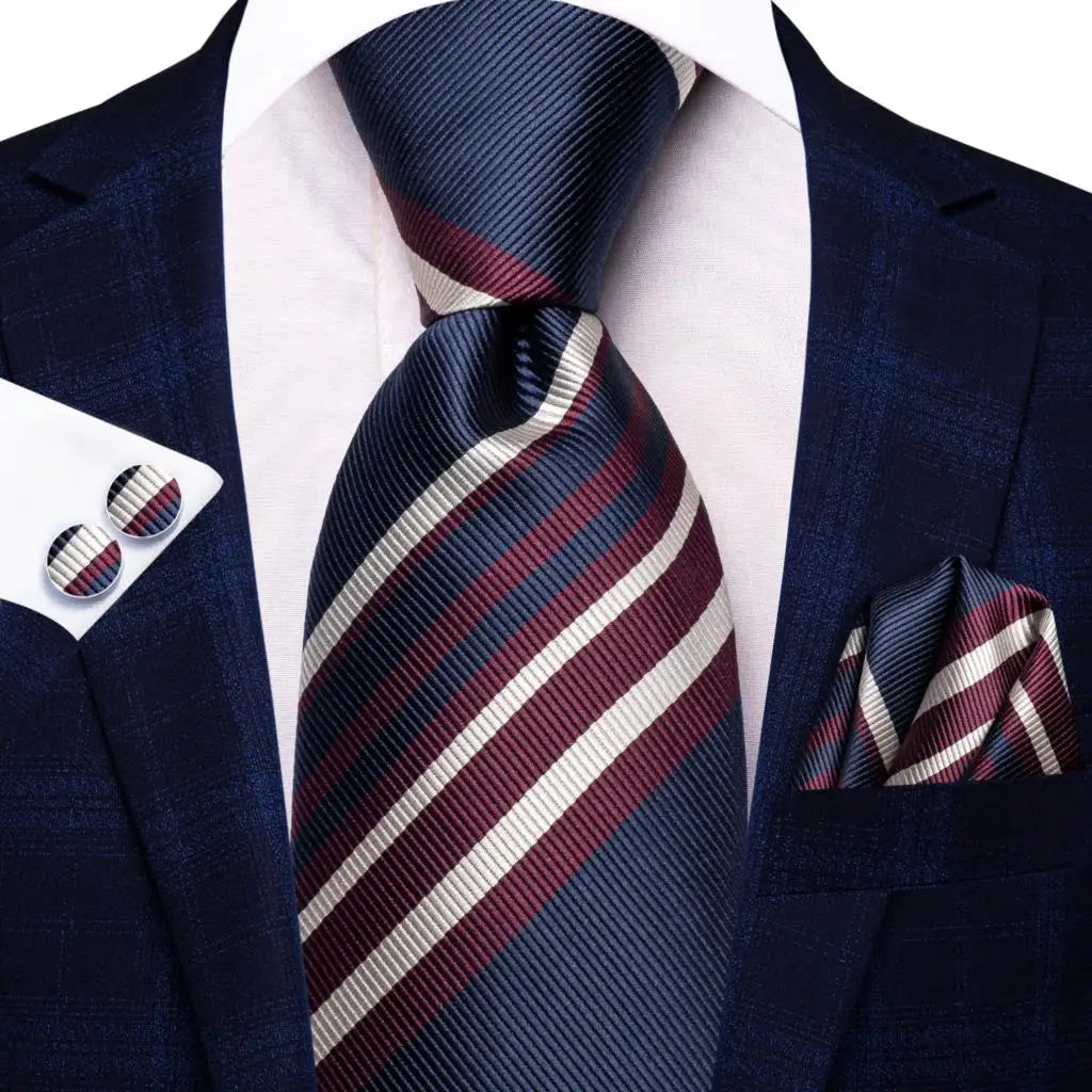 Mens navy suit with red and white striped tie, pocket square, and cufflinks, learn how fold a pocket square