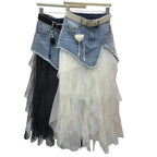 Denim skirt with lace overlay on a hanger against a white wall.