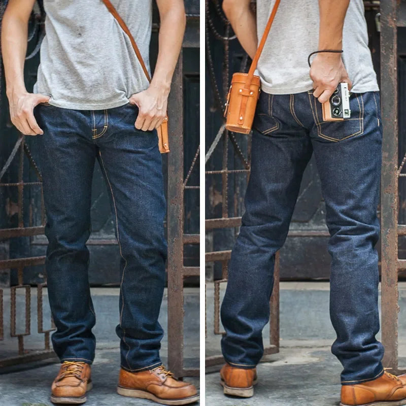 Person wearing blue jeans and brown shoes with a leather bag and phone case.