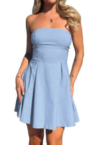 Woman wearing a light blue strapless dress outdoors.
