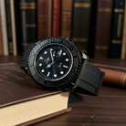 Black wristwatch on a book with a background of books