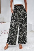 VacationGrabs women's allover print vacation pants in black with white abstract floral design and wide-leg fit