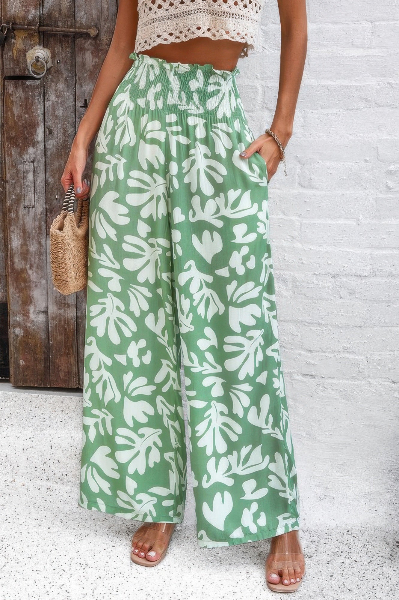 Women’s green allover print vacation pants with white leaf patterns and elastic waistband
