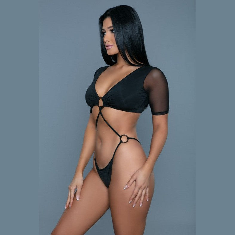 BE WICKED model wearing sexy black cutout swimsuit with ring connectors high cut bottom and sheer short sleeves