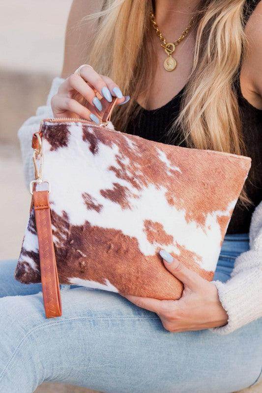 Aili's Corner animal print clutch bag with a brown and white cowhide pattern for stylish outings