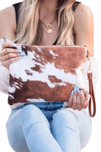 Brown and white animal print clutch bag featuring a stylish wrist strap for easy carrying