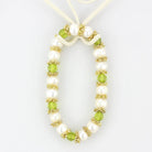 Antique silver women's bracelet adorned with white pearls and green crystals for an elegant touch