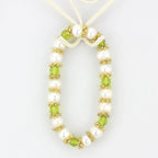 Antique silver women's bracelet adorned with white pearls and green crystals for an elegant touch