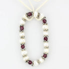 Antique silver women's bracelet adorned with pearls and garnet beads for elegant occasions