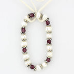 Antique silver women's bracelet adorned with pearls and garnet beads for elegant occasions