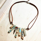 Aqua Terra leather necklace featuring multi-colored pendants on a brown cord for a unique accessory
