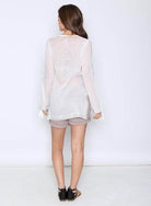 Back view of a Women's Aztec long sleeve top by Qwasabee in light fabric, styled with shorts