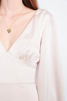 Close-up of a Women's back strap tulip mini dress by Emory Park, featuring a v-neck and long sleeves