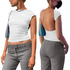 White backless clubwear slim fit top with short sleeves worn with gray pants and a blue shoulder bag