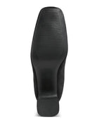 Bottom view of beige square toe heeled booties showcasing the textured sole for better traction
